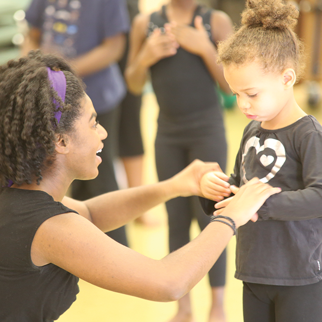 Roots & Branches Image - Instructor helps young dancer